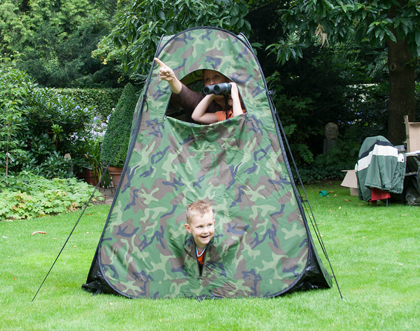 A family doing birdwatching from an observation tent.