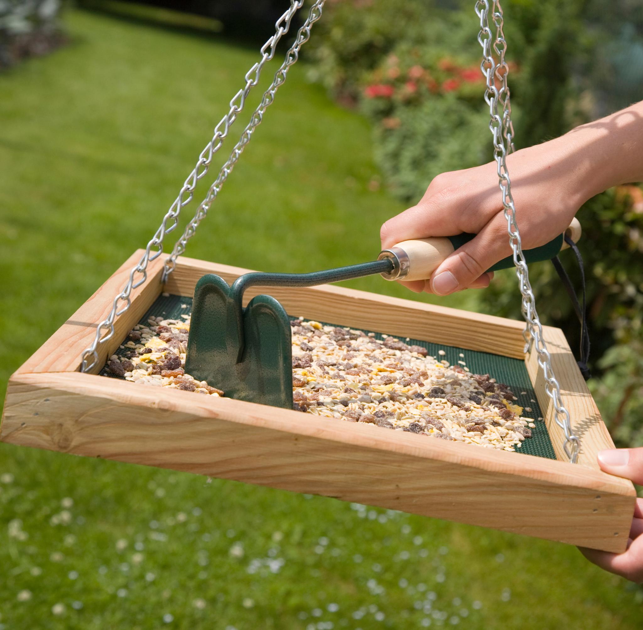 Child smiles while presenting the assembled nest box building kit